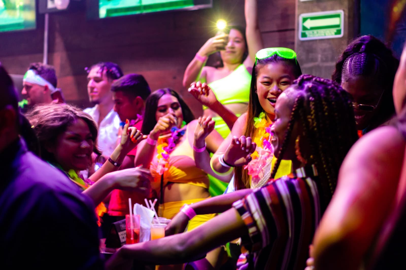 Crowd dancing under neon lights on a Best Clubs in Cancun open-bar night